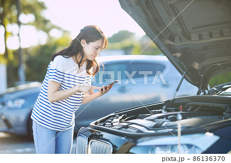 車の故障で電話をする若い女性 車の故障で電話をする若い女性 86136370