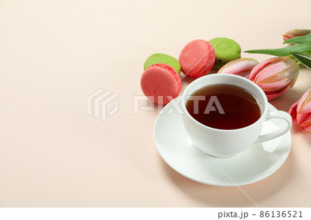 Tea, tulips and macaroons on beige background 86136521