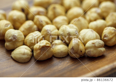 木の皿に乗ったたくさんのヘーゼルナッツ 86136672