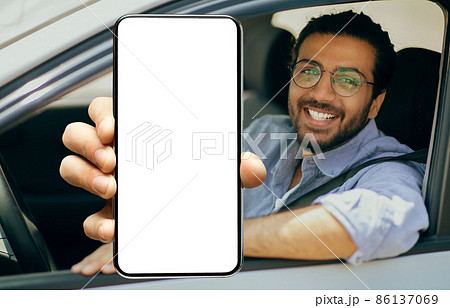 Happy indian driver using showing smartphone with empty screen Happy indian driver using showing smartphone with empty screen 86137069