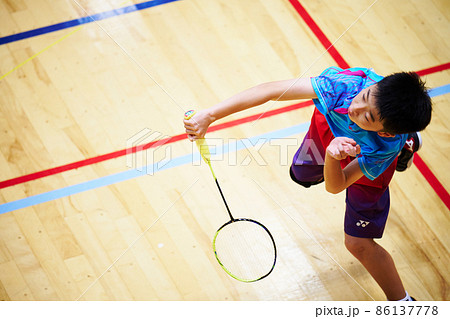 バドミントンの試合をする小学生男子 86137778