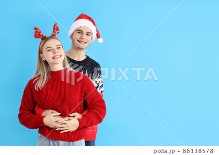 Cute couple in Christmas clothes on blue background 86138578