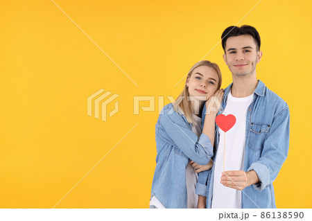 Cute couple with heart on yellow background Cute couple with heart on yellow background 86138590