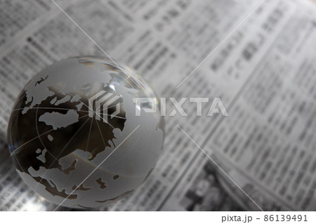 ガラスの地球儀と新聞 グローバルなニュースや時事問題 イメージ ガラスの地球儀と新聞 グローバルなニュースや時事問題 イメージ 86139491