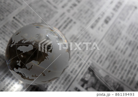 ガラスの地球儀と新聞 グローバルなニュースや時事問題 イメージ ガラスの地球儀と新聞 グローバルなニュースや時事問題 イメージ 86139493