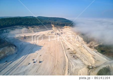 Aerial view of open pit mining of limestone materials for construction industry with excavators and dump trucks. 86141164