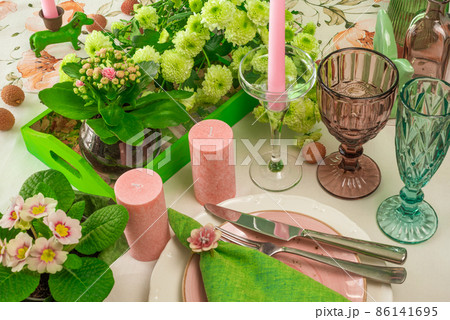 Romantic spring table setting for two with wine glasses, candles and flowers 86141695
