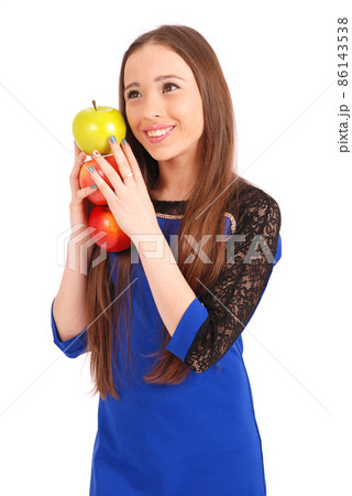Young smiling brunette girl holding three apples Young smiling brunette girl holding three apples 86143538