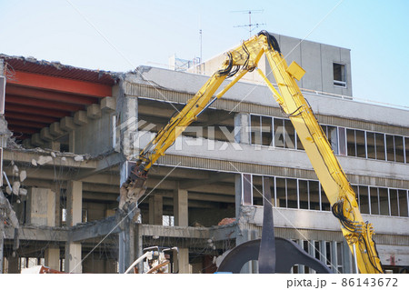 老朽化した公共建造物の解体作業をする重機 86143672