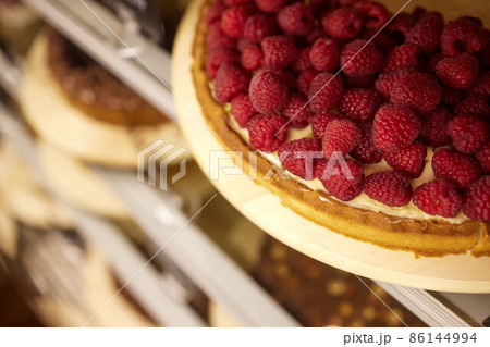 Tart with raspberries and whipped cream decorated with mint leaves. 86144994