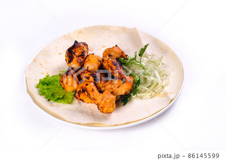 Chicken meat on pita bread with vegetables on a white plate on a white isolated background Chicken meat on pita bread with vegetables on a white plate on a white isolated background 86145599