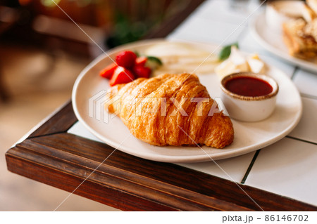 Golden croissant with strawberry marmalade and berries Golden croissant with strawberry marmalade and berries 86146702