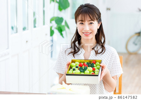 フルーツの詰め合わせを持った女性 フルーツの詰め合わせを持った女性 86147582