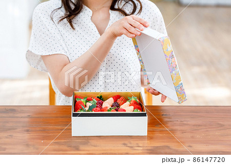 フルーツの詰め合わせを開ける女性 86147720