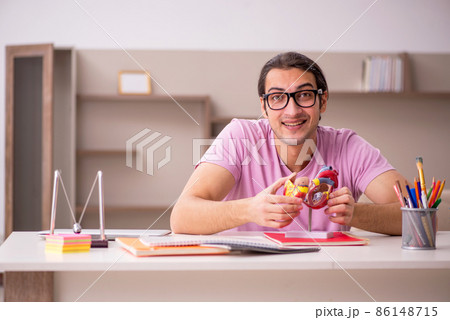Young male student cardiologist preparing for exam at home Young male student cardiologist preparing for exam at home 86148715