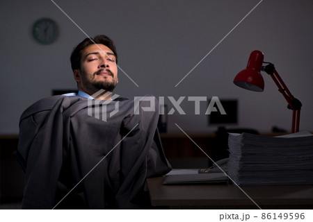 Young male employee working late in the office Young male employee working late in the office 86149596