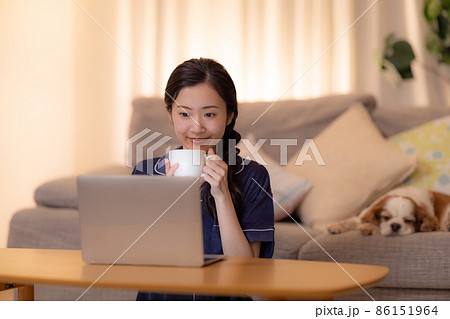 夜のリビング　パソコンを見ながら寛ぐ女性 86151964