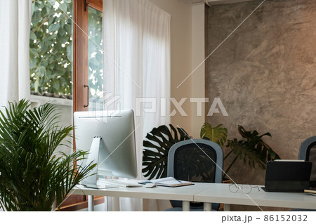 Wooden work desk with pc computer and documents, books, modern interior of cozy cabinet, table for businessman or student at home, comfortable workspace, workplace with computer in apartment. Wooden work desk with pc computer and documents, books, modern interior of cozy cabinet, table for businessman or student at home, comfortable workspace, workplace with computer in apartment. 86152032