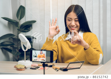 Asian teenage girls doing makeup vlogs and using a video mobile camera to record vlogs and publish them online at home. Asian teenage girls doing makeup vlogs and using a video mobile camera to record vlogs and publish them online at home. 86152742