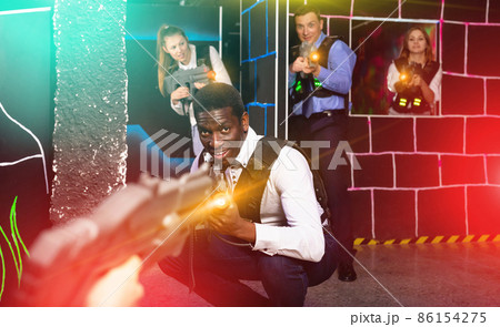 Men and women in business suits playing laser tag emotionally in 86154275