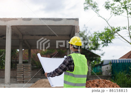 engineer concept The constructing manipulator who wears a hard yellow hat, dark-toned plaid blouse and soft green vest looking at the processing building construction engineer concept The constructing manipulator who wears a hard yellow hat, dark-toned plaid blouse and soft green vest looking at the processing building construction 86158815