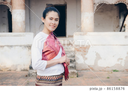 Portrait of Asian woman wearing Laos traditional clothing in front of old temple in Luang Prabang, the UNESCO world heritage site in north central of Laos. 86158876