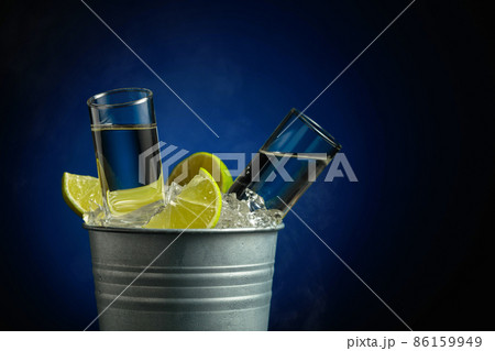 Strong alcoholic drink with lime slices in a bucket with ice. Strong alcoholic drink with lime slices in a bucket with ice. 86159949