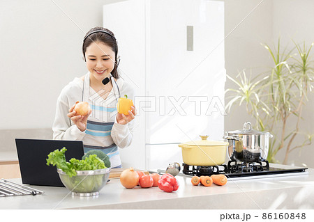 おうち時間 パソコンを使いながら料理をする若い女性 おうち時間 パソコンを使いながら料理をする若い女性 86160848