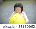風船を膨らます少女 86160962