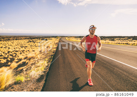 Sport run triathlon compettion man running on road during marathon race. Male athlete in compression tri suit 86161049