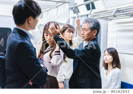 電車内で取り押さえられる中年男性 86162642