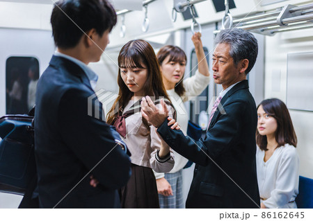 電車内で取り押さえられる中年男性 86162645