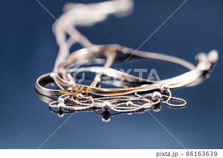 Gold rings with different precious stones lie surrounded by beautiful gold chains Gold rings with different precious stones lie surrounded by beautiful gold chains 86163639