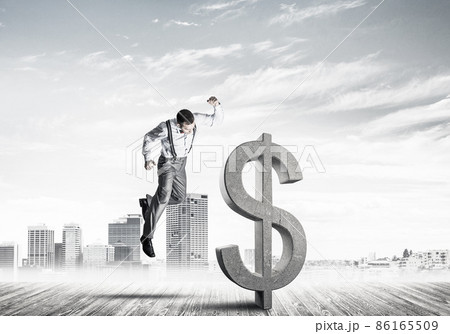 Determined banker man against modern cityscape breaking dollar concrete figure 86165509