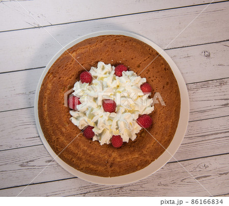 Pastry, Traditional Italian rum cake with whipped cream and raspberries Pastry, Traditional Italian rum cake with whipped cream and raspberries 86166834