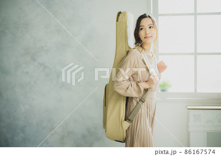 ギターケースを持つ女性 86167574