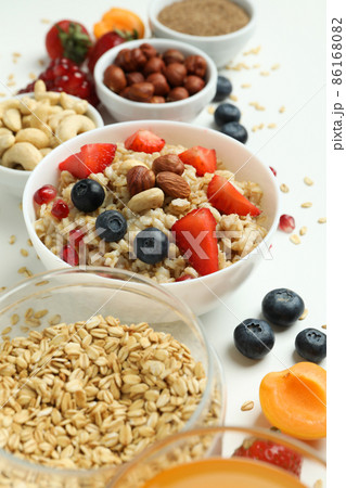 Bowl of oatmeal and ingredients on white background 86168082