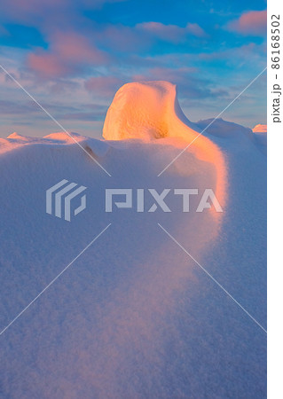 Snowdrift waves in sunset light, purple evening light at winter with a lot of snow, vertical image 86168502