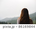 Young redhead woman admires mountains in autumn, back view. 86169844