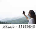 Young millennial woman admires mountains in autumn and taking selfie, picture. 86169845