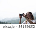 Young millennial woman admires mountains in autumn and taking selfie, picture. 86169852