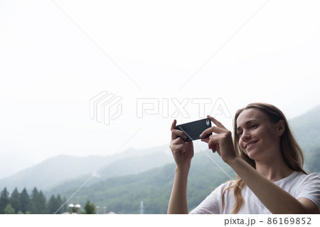 Young millennial woman admires mountains in autumn and taking selfie, picture. 86169852