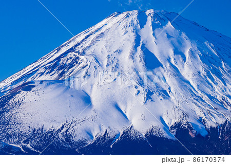 乙女峠から見た真っ白な雪化粧の富士山、横からの光で立体感ある