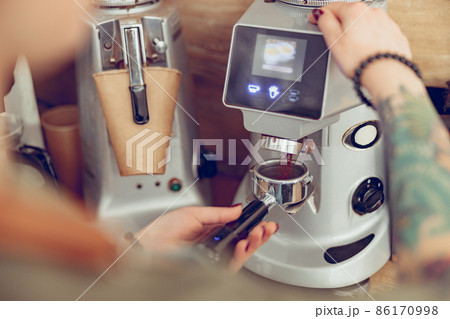 Female barista hands using professional coffee machine in cafe Female barista hands using professional coffee machine in cafe 86170998