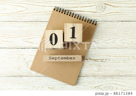 Notebook and wooden calendar with September 1 on white wooden background 86171384
