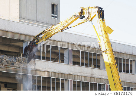 老朽化した公共建造物の解体作業をする重機 86173176