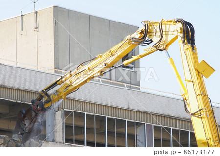 老朽化した公共建造物の解体作業をする重機 86173177