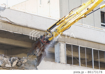 老朽化した公共建造物の解体作業をする重機 86173178