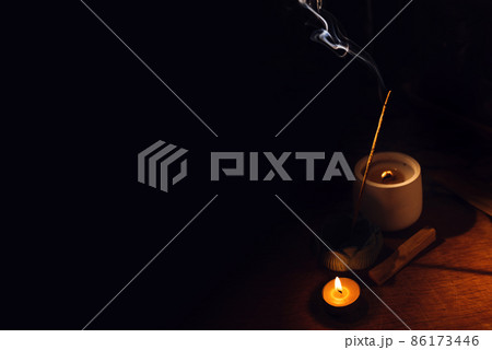 Incense aroma sticks smoldering on table lotus holder and candle in darkness. Zen, meditation, mental health comfort zone 86173446