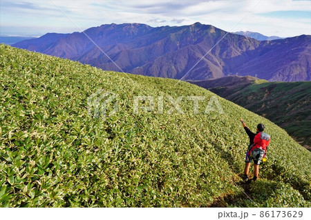 七ツ小屋山からの巻機山と笹原と登山者 86173629
